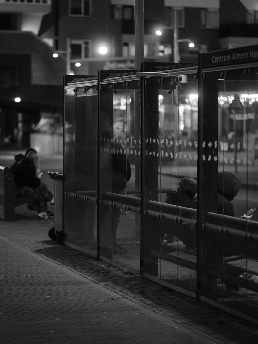 People waiting at a city bus stop